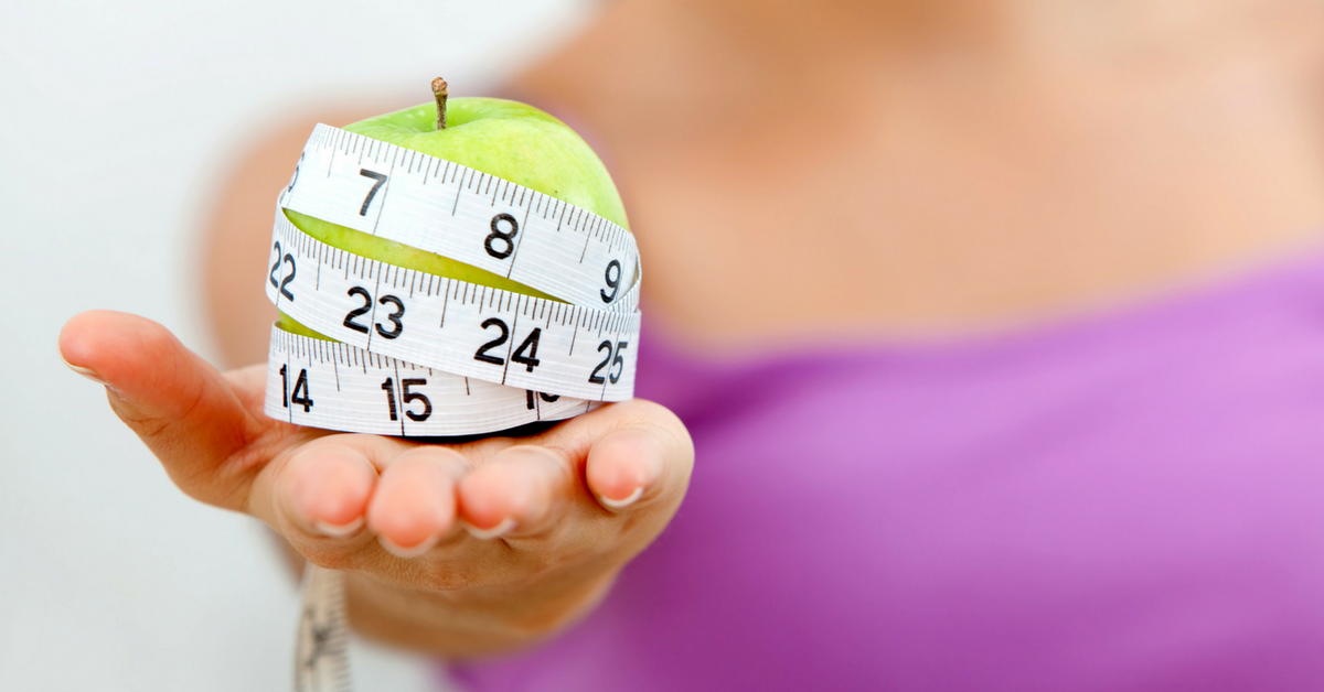 lady-holding-apple-with-measuring-tape