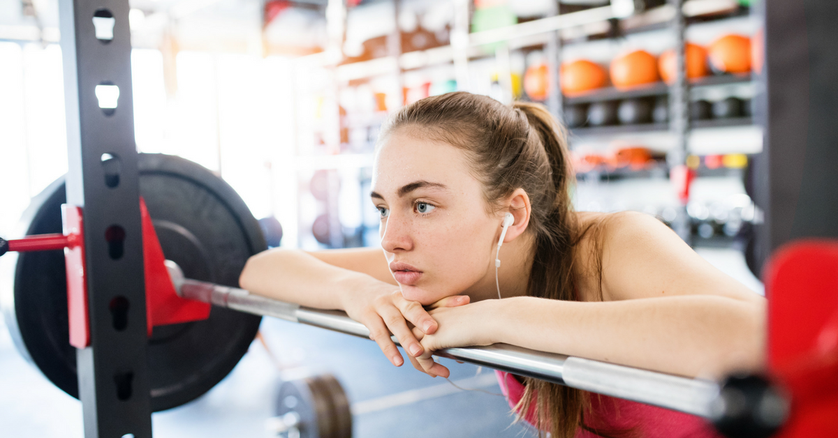 women-barbell-squatting-with-headphones